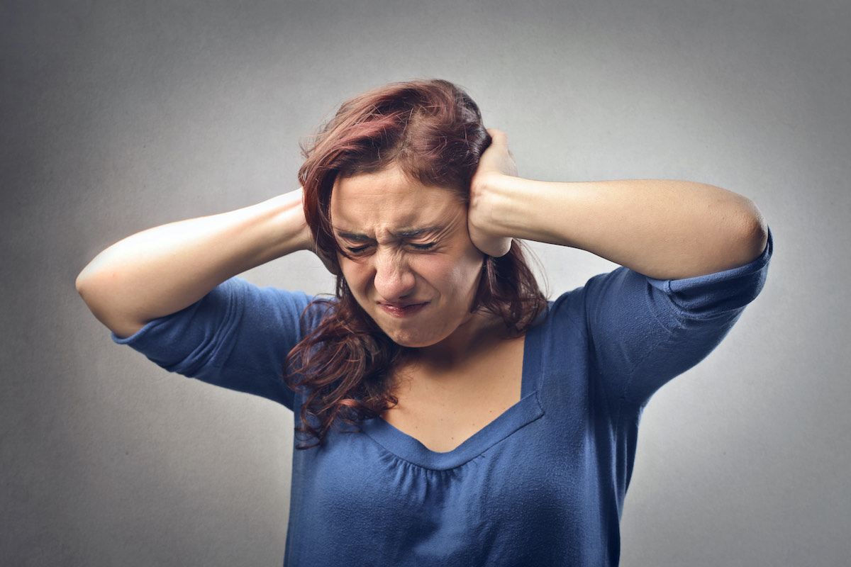 woman covering ears noisy neighbours